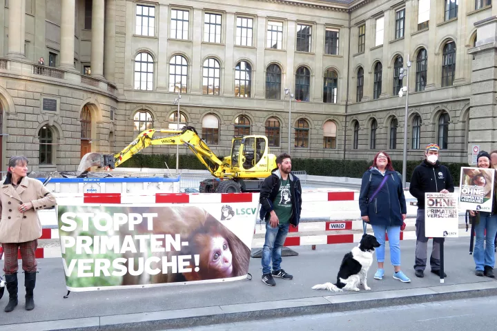 Aktivist*innen stehen mit einem Transparent und Plakten mit der Aufschrift "Stoppt Primatenversuche!" sowie "LSCV“ vor dem Hauptgebäude der ETH.