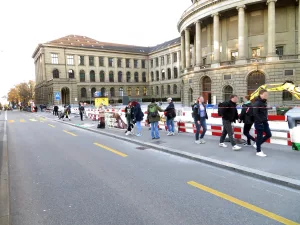 Aktivist*innen stehen mit einem Transparent und Plakten mit der Aufschrift "Stoppt Primatenversuche!" sowie "LSCV“ vor dem Hauptgebäude der ETH.