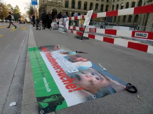 Aktivist*innen stehen mit einem Transparent und Plakten mit der Aufschrift "Stoppt Primatenversuche!" sowie "LSCV“ vor dem Hauptgebäude der ETH.